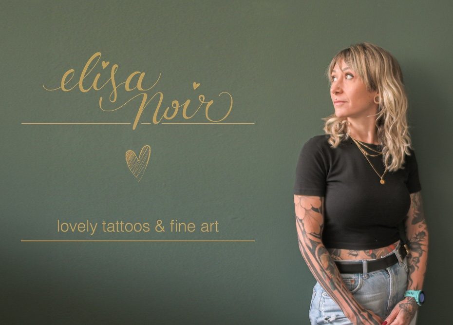 Elisa Noir vor einer grünen Wand mit dem Schriftzug „elisa noir, lovely tattoos & fine art“